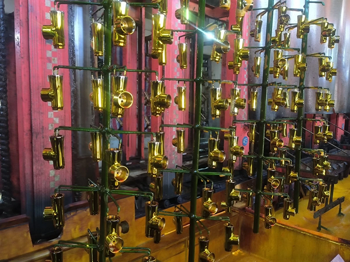 Plating rack lifted from a process tank with solution draining back, showing drag-out