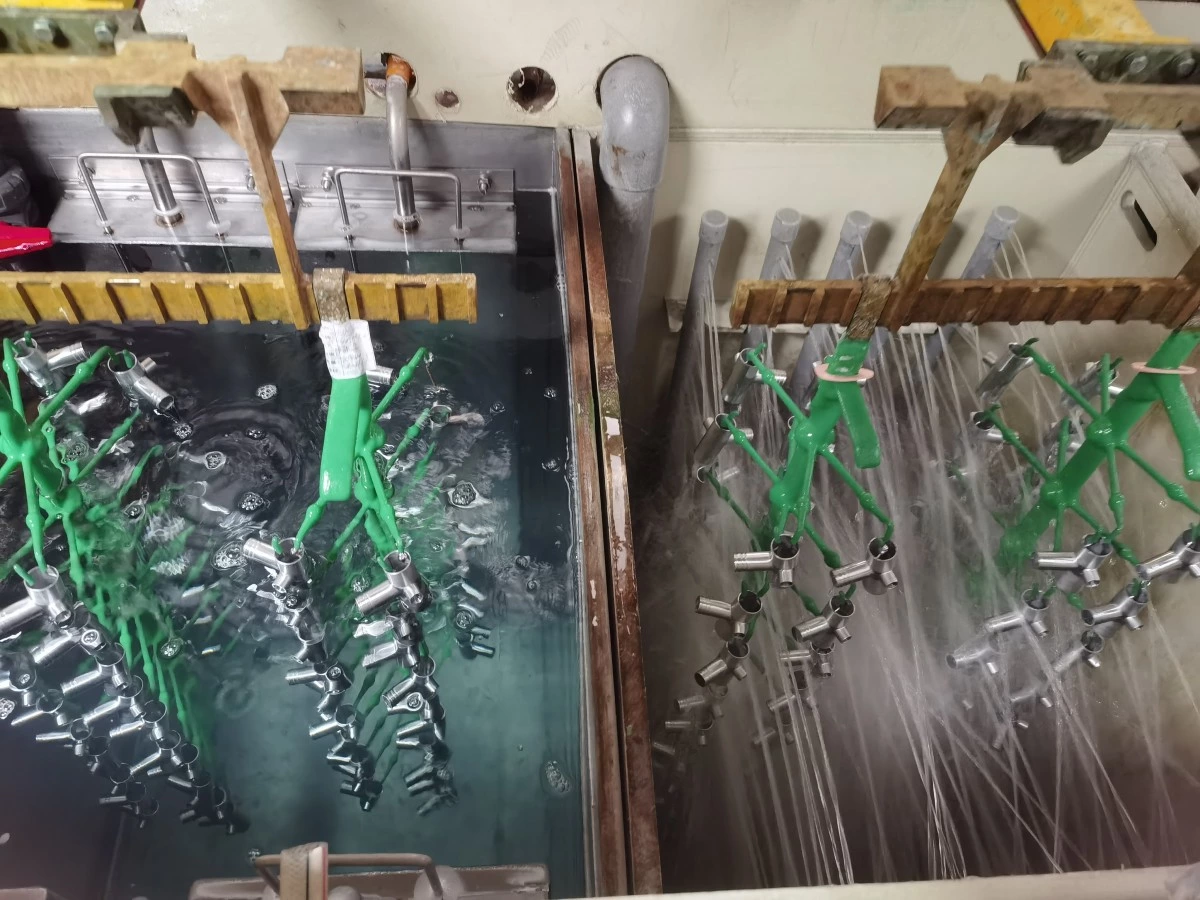 Plating barrel rotating above a rinse tank to release solution trapped between parts