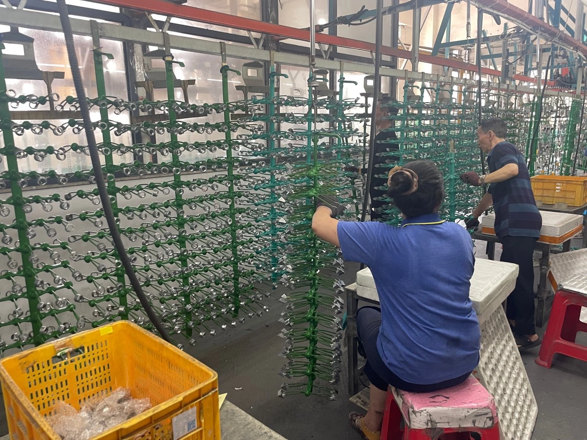 Operators loading parts onto electroplating racks