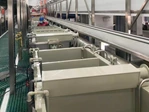 Process tank row beneath the transfer rails of an electroplating line