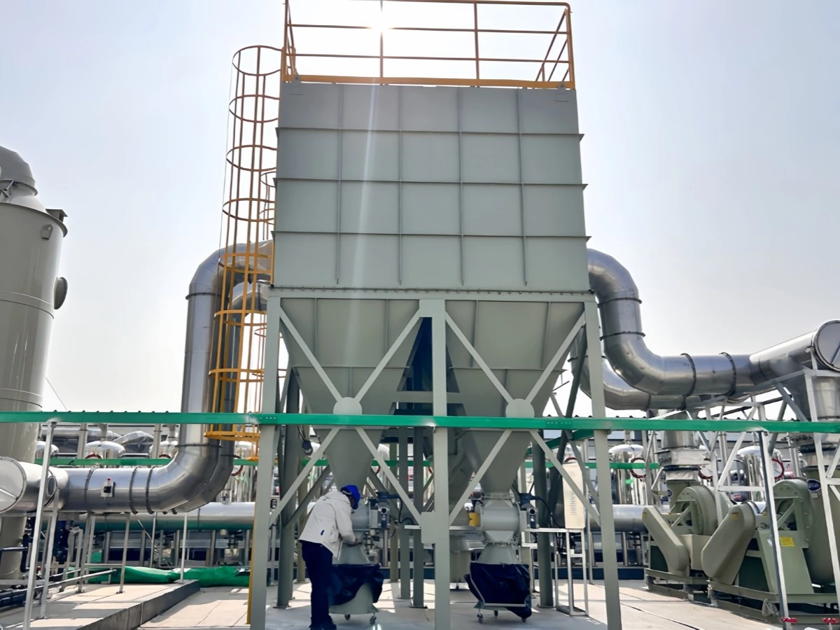 Technician working beneath an industrial baghouse dust collection system