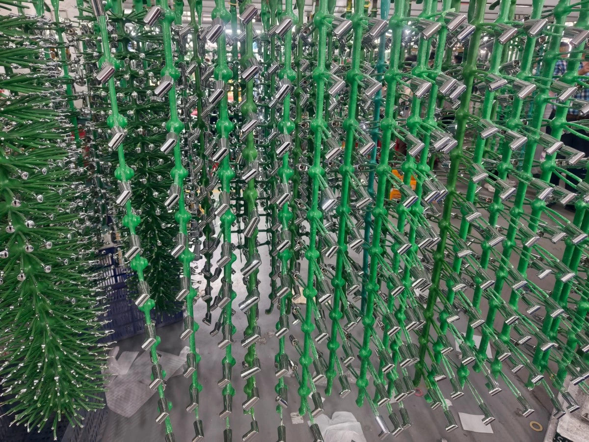 Metal parts loaded on a rack above an electroplating tank