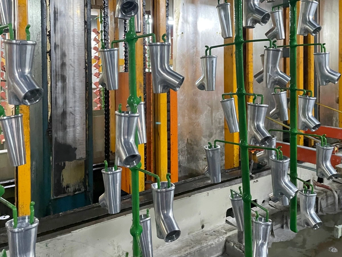 Loaded workpiece racks beneath the lifting equipment on an electroplating line